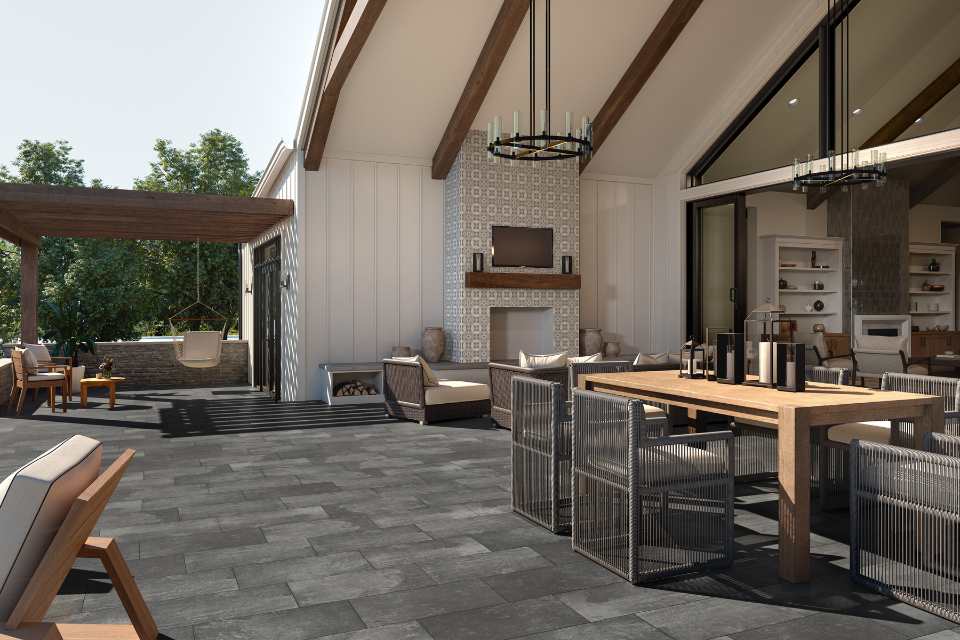 dark porcelain tile in outdoor kitchen/living space with large dining table and tiled fireplace